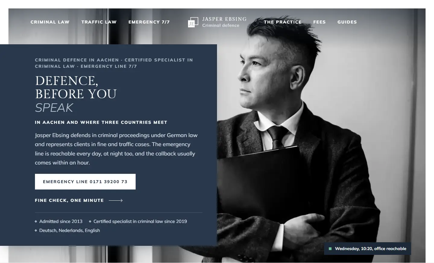 Home page of the criminal defence template with a framed black and white portrait of a man in a tweed jacket holding a folder, a navy panel over its edge with the headline about defence before you make a statement and buttons for the emergency line and the fine check